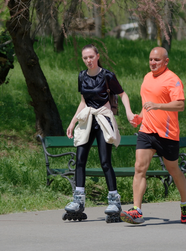 Woman rollerblading with a man running